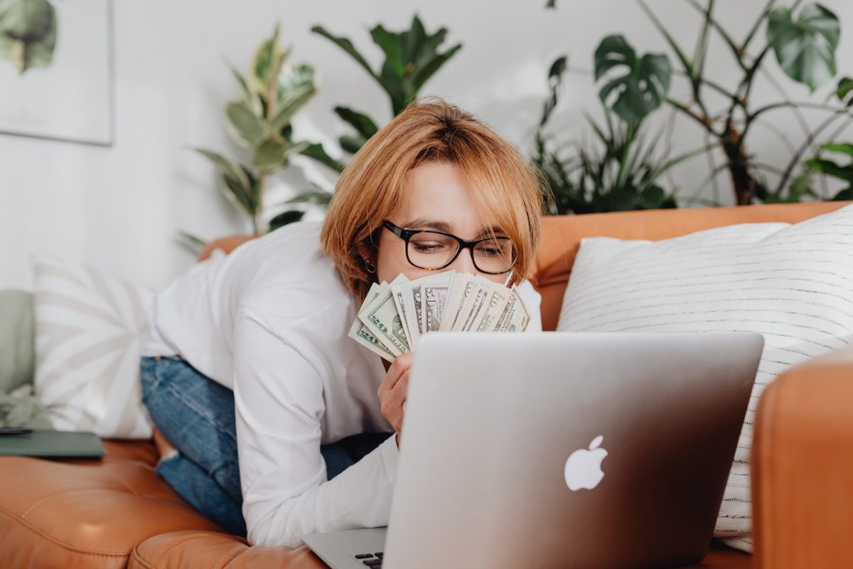 Photo by Karolina Grabowska: https://www.pexels.com/photo/woman-sitting-on-a-couch-in-front-of-a-laptop-and-covering-her-face-with-money-5902939/