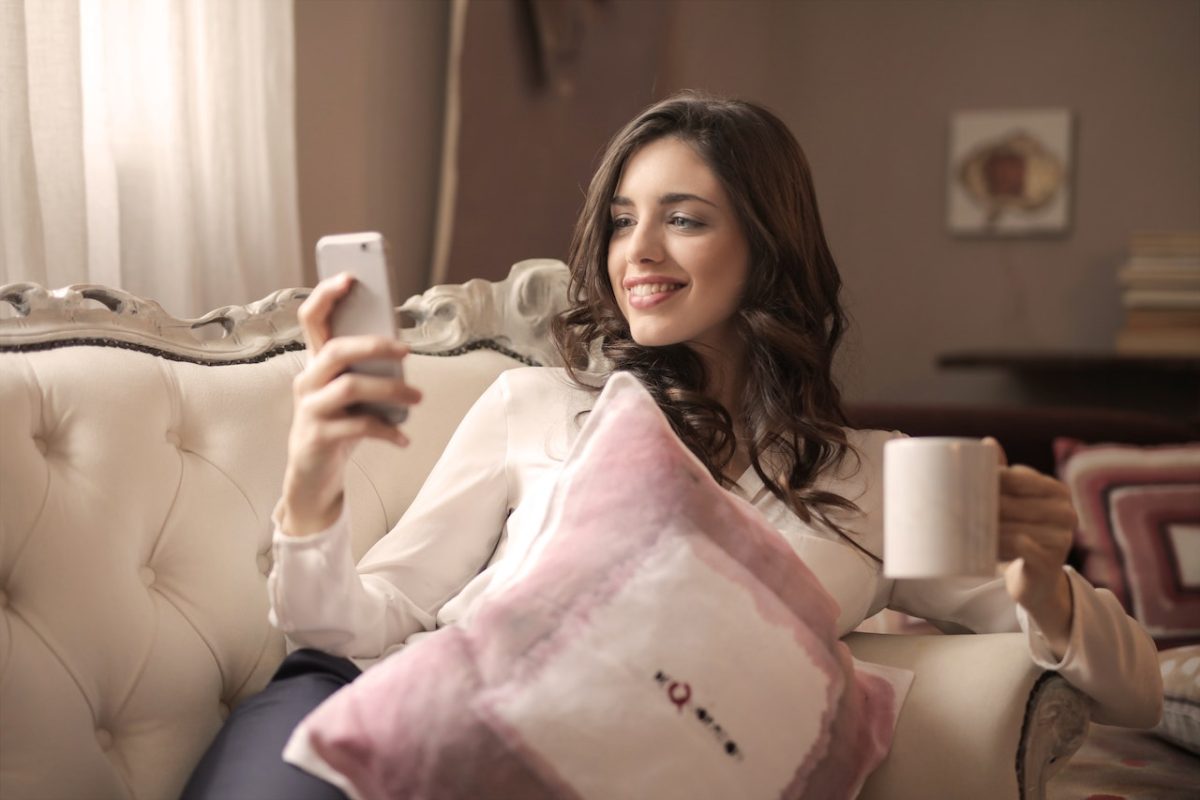 Photo by Andrea Piacquadio: https://www.pexels.com/photo/woman-in-white-long-sleeved-shirt-holding-smartphone-sitting-on-tufted-sofa-920378/